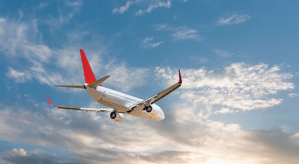 White passenger airplane flying in the sky amazing clouds in the background - Travel by air transport