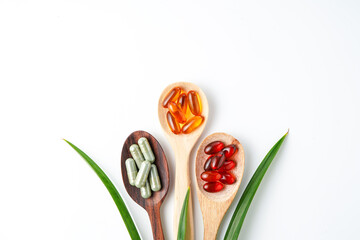 Different pills, herbs vitamin and mineral pills in wooden spoon flat lay Dietary supplements
