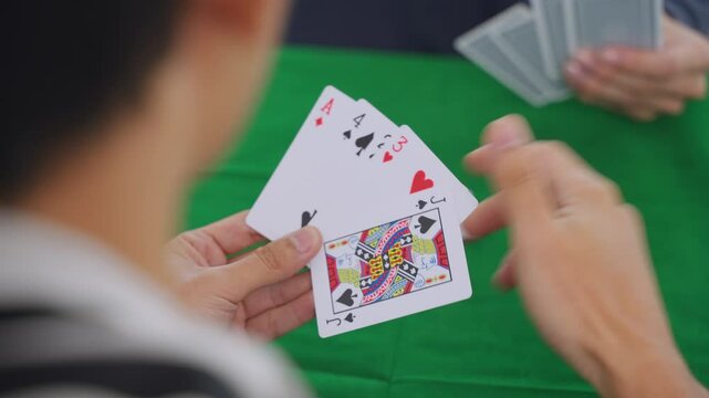 Close up of young men poker players playing casino card game in house. 