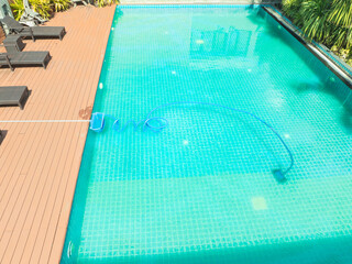 Pool maintenance with scoop net  and automatic robot cleaner.
