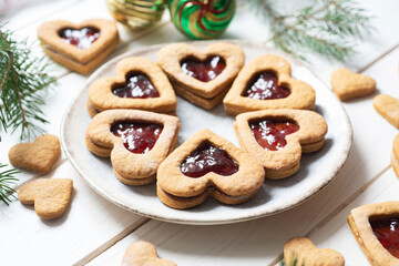Sweet dessert for breakfast: cookies with jam in the shape of a heart on a white background. Close-up