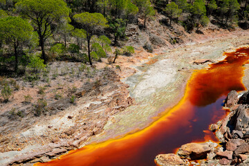 Rio Tinto river and iron mines. Red tinted river by copper, iron on the ground. Water used in life...