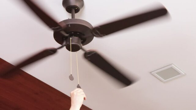 Anonymous turn off wooden ceiling fan. Modern device for cooling room with variable speed control. Summer and heat.