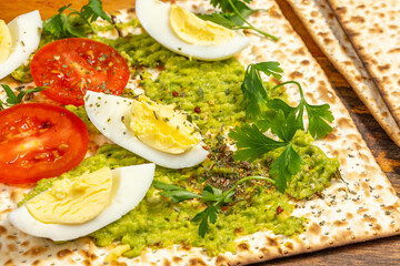 Matzah toast made with creamy avocado, grilled zucchini, fresh tomatoes, boiled eggs.