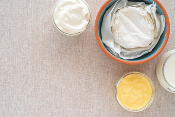 Camembert, sour cream, sour milk for Jewish holiday Shavuot, for Harvest on cotton fabric background.