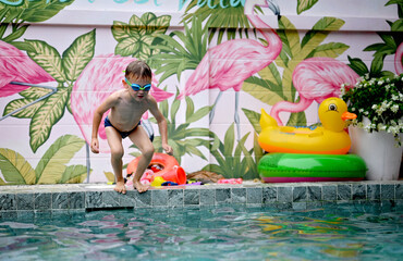 Naklejka premium Boy has fun in swimming pool