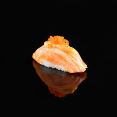 Close-up of a delectable salmon nigiri sushi garnished with a delicate topping, isolated on a dark background