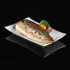 Grilled Sea Bream Dorado fillets served on fresh salad. Black background. Top view.