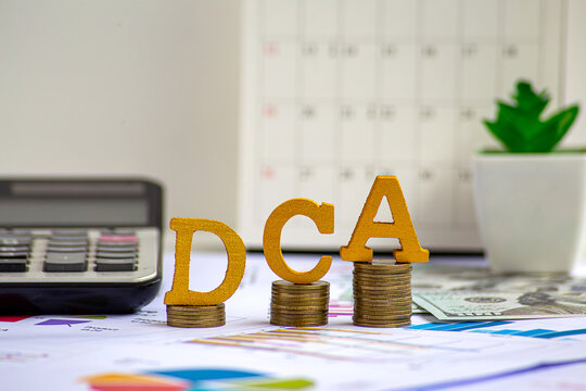 DCA text on wooden blocks on growth of coins stack. Background for Dollar cost averaging investment strategy, Saving stock monthly, Quarterly basis. Fund purchases, Business and investment concept.