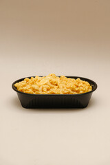 Mac and cheese tasty Italian pasta with Cheddar cheese on plain background
