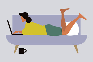 The girl is sitting on the sofa working on her laptop.