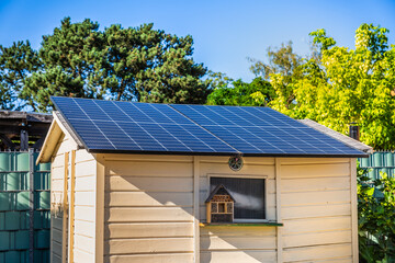 Small solar panels installed on garden shed, backyard shed