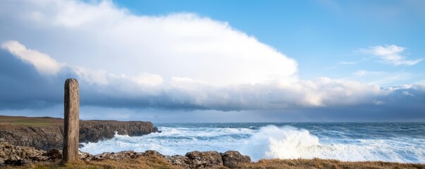 Cloudburst over a rocky coastline, waves crashing against cliffs