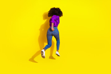 Fototapeta na wymiar Full body photo of pretty young girl running behind view wear trendy violet outfit isolated on yellow color background