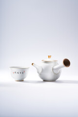 Traditional Chinese teapot and teacup on white background, tea ceremony utensils