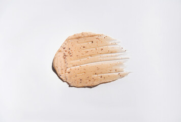 Close-up of a smear of a skin scrub on a white background. Texture of skin care cosmetic product. Cleansing and exfoliating your skin.