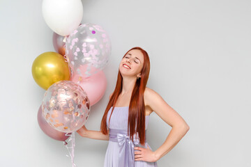 Happy young millennial attractive redhead woman hold balloons smiling celebrating her birthday at home holiday party.Womens,Valentines,Mother day