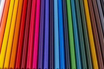 Colored pencils neatly arranged on a school desk in the classroom
