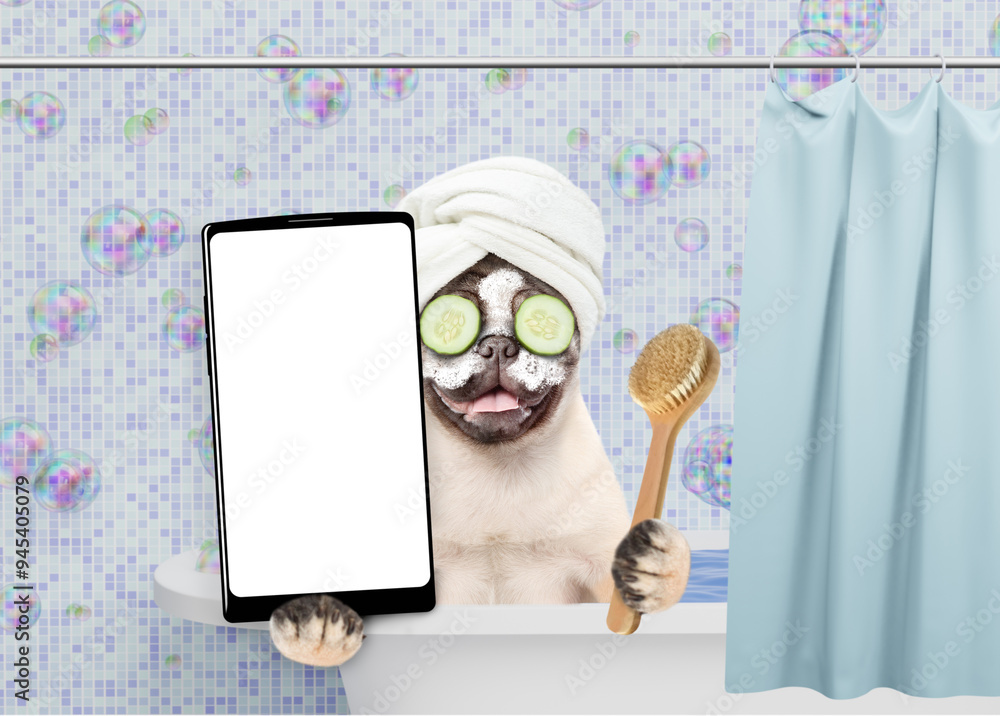 Poster Happy Pug puppy with towel on it head and cream on it face and with slices of cucumber in it eyes takes the bath and shows big smartphone with white blank screen in it paw. Empty space for text