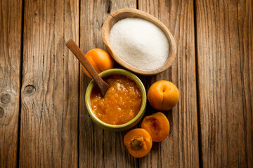apricot jam with ingredients over wood background