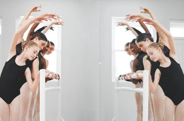 Girl, team and ballet dancers with mirror for performance, stretching or warm up together in studio. Young group, female person or ballerina leaning in pose, row or line for practice or reflection