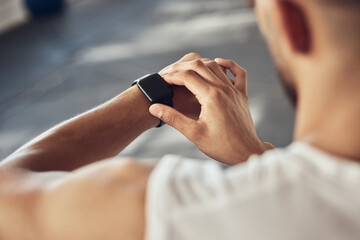Man, fitness and checking with smart watch for tracking, performance or progress on workout at gym....