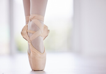 Person, feet and ballet with balance on toes for dance routine, practice or training on floor at studio. Closeup of dancer, foot or ballerina in pointe or performance for skill, talent or technique