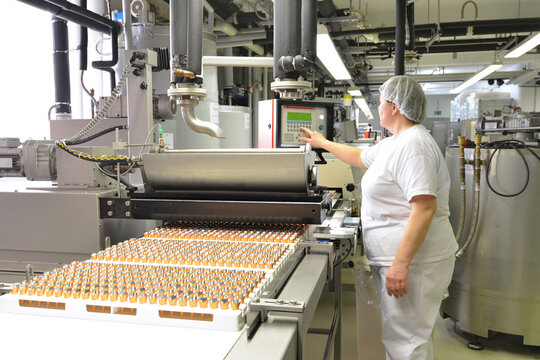 Production of pralines in a factory for the food industry - automatic conveyor belt with chocolate