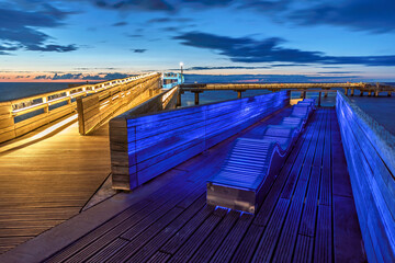 Naklejka premium Part of the wooden pier of German city Heiligenhafen at the Baltic Sea at blue hour