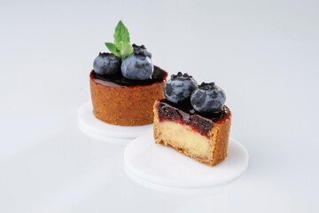 Made by professional baker. Delicious tart with blueberries against white background