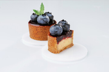 Made by professional baker. Delicious tart with blueberries against white background