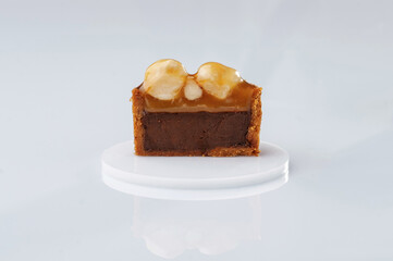 Single caramel tart with walnut against white background
