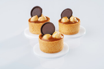 Caramel tart with walnut against white background