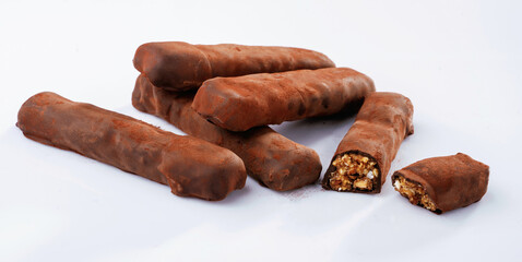 Brown colored chocolate bars lie on a white surface, isolated