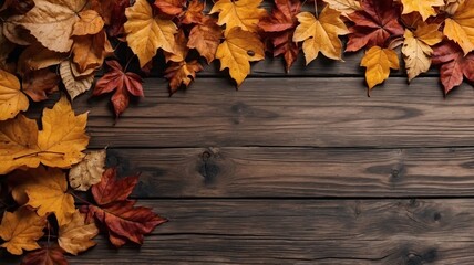 Autumn leaves in various colors are arranged on a dark wooden surface, highlighting the rich and warm tones of the season.