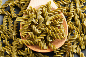 Dietary pea spiral pasta fusilli with the addition of wakame seaweed in wooden spoon for a...