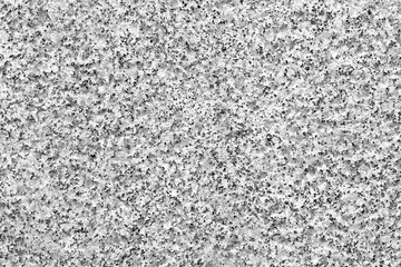 Decorative grainy granite gray wall with white and black particles. Abstract background