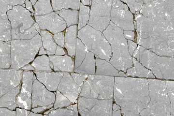 Cracked exterior floor tile abstract distressed surface. Gray abstract broken background