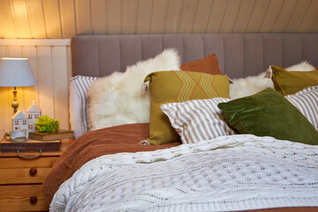Modern bedroom interior, double bed with beige linen bedspread and colorful pillows