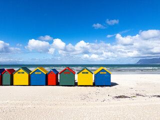 The iconic Muizenberg Beach huts for people to change in and out of bathing suits situated on Muizenberg Beach, Cape Town, South Africa