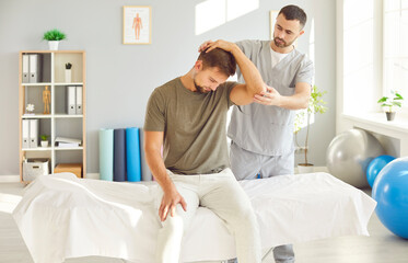Therapist providing a neck and hand massage to a patient during a rehabilitation session in a...