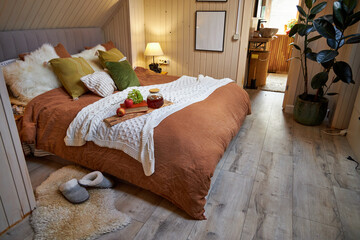 Modern bedroom interior, double bed with beige linen bedspread and colorful pillows