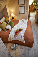 Modern bedroom interior, double bed with beige linen bedspread and colorful pillows