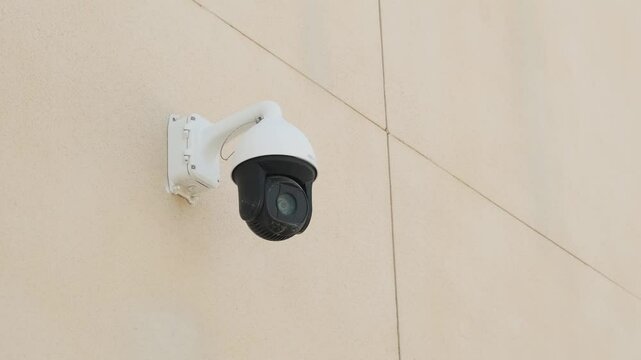 CCTV camera monitoring system with panoramic view rotating outdoor on the wall. Safety system in the city. Surveillance video camera. Technology concept