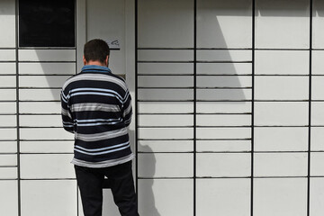A man at a parcel locker receiving a parcel