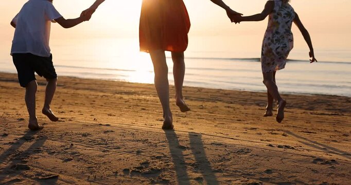 family running into the sea water at sunset