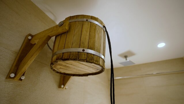 Wooden bucket shower slowly filling with water.