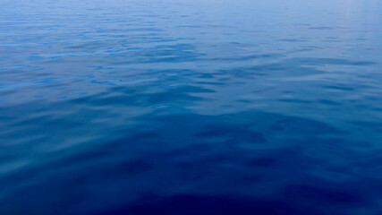 Obraz premium Blue water background. Calm sea surface. Top view of calm blue ocean surface. Water surface background. Water texture.