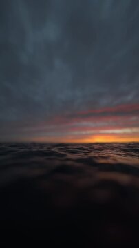 Sea wave close up, low angle view, slow motion sunrise or vertical looping animation sunset shot. 3d rendering not AI