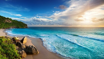 blue skies and fluffy clouds over the rocks at sunset; view of a tropical beach with soft turquoise ocean waves, sun setting behind long cliffs